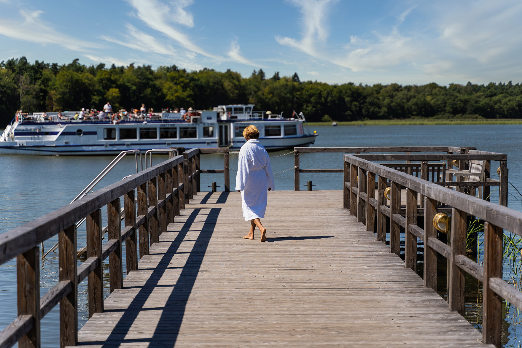 Steg mit Frau und Schiff_Seehotel Rheinsberg